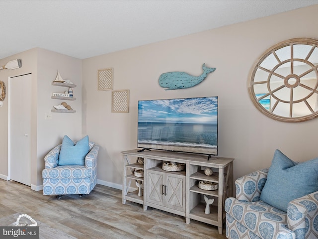 living area featuring baseboards and wood finished floors