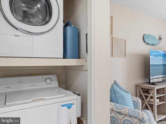 washroom featuring a textured ceiling, laundry area, and stacked washing maching and dryer