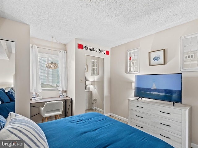 bedroom with baseboards and a textured ceiling