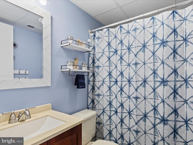 full bathroom with toilet, vanity, curtained shower, and visible vents