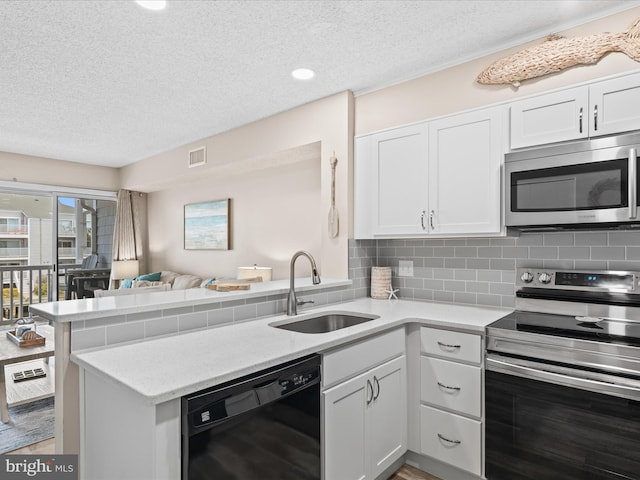 kitchen with backsplash, a sink, stainless steel appliances, and visible vents