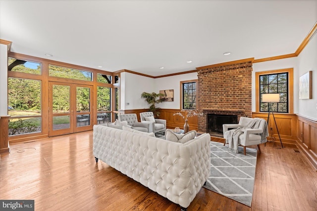 living area with a wainscoted wall, plenty of natural light, hardwood / wood-style floors, and a fireplace