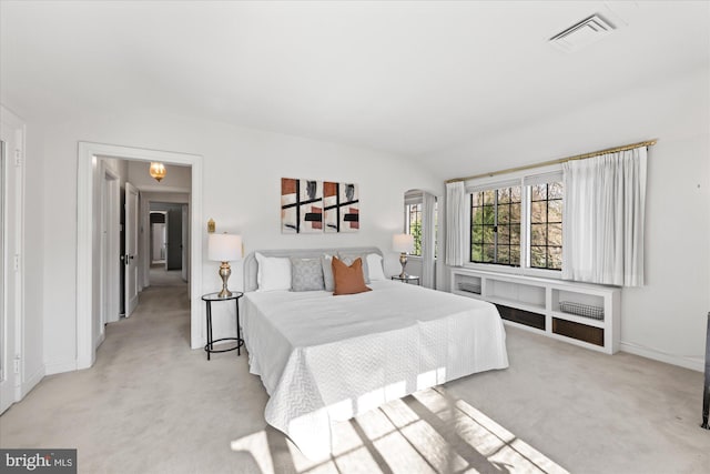 bedroom featuring visible vents, arched walkways, light colored carpet, and baseboards