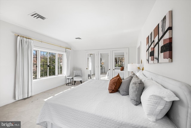 carpeted bedroom featuring visible vents and lofted ceiling