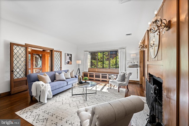 living area featuring visible vents, a fireplace, radiator, and dark wood-type flooring