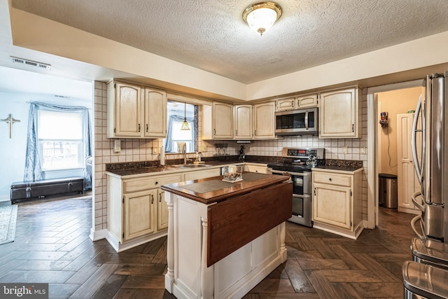 kitchen featuring a center island, light brown cabinets, tasteful backsplash, and stainless steel appliances