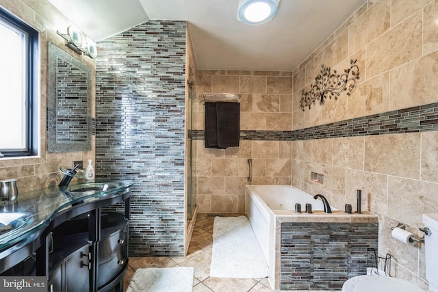 full bathroom featuring tile patterned floors, a garden tub, tile walls, and vanity