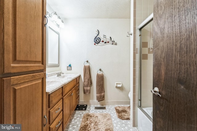 bathroom featuring tile patterned flooring, baseboards, double vanity, a textured ceiling, and a sink