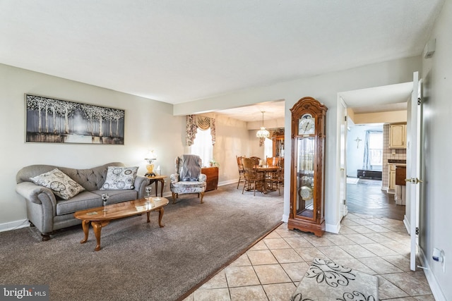 living area featuring light tile patterned floors, baseboards, and light colored carpet