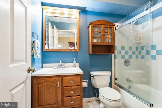 bathroom featuring tile patterned floors, toilet, baseboards, bath / shower combo with glass door, and vanity