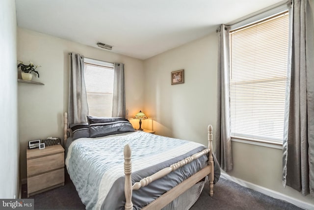 carpeted bedroom with visible vents and baseboards