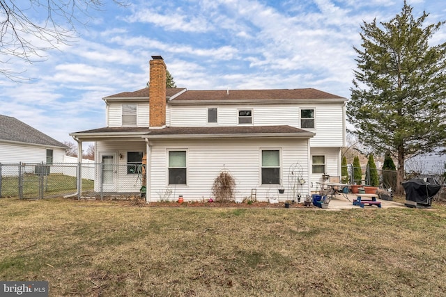 back of property with a patio area, a chimney, a yard, and fence