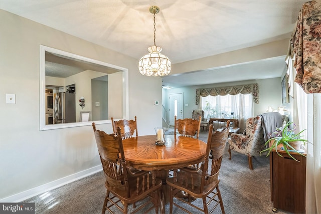 carpeted dining room featuring baseboards