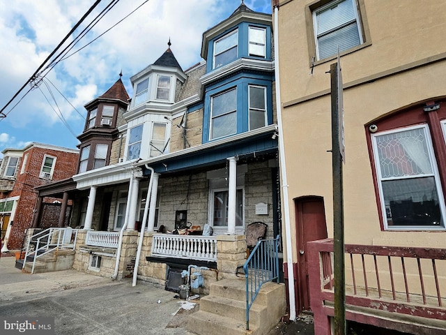 townhome / multi-family property with stucco siding and covered porch