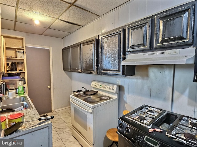 kitchen with a drop ceiling, a sink, under cabinet range hood, marble finish floor, and white range with electric stovetop