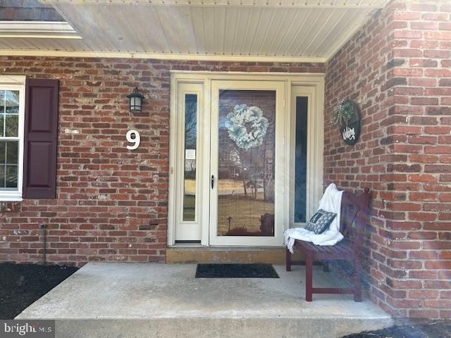 view of exterior entry featuring brick siding