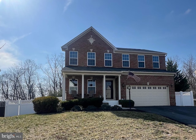 view of front of home featuring aphalt driveway, a garage, fence, and brick siding