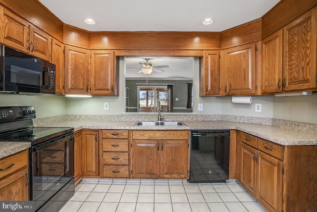 kitchen with brown cabinetry, black appliances, and a sink