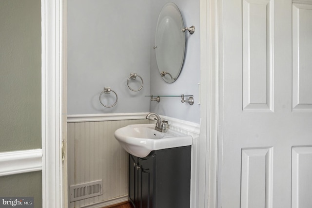 bathroom with a sink, visible vents, and wainscoting