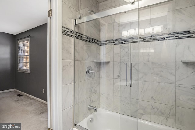 full bath with combined bath / shower with glass door and baseboards