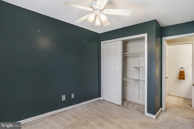 unfurnished bedroom featuring a ceiling fan, baseboards, a closet, and light carpet