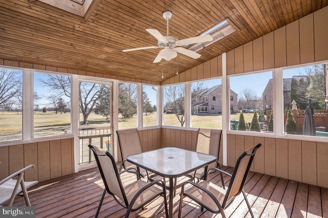 unfurnished sunroom with lofted ceiling with skylight, wood ceiling, a wealth of natural light, and ceiling fan