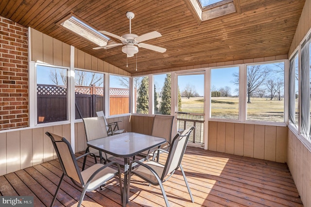 unfurnished sunroom with ceiling fan, lofted ceiling with skylight, and wooden ceiling