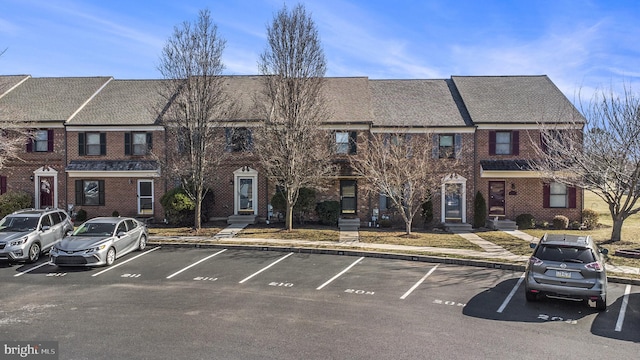 view of front of property with brick siding and uncovered parking