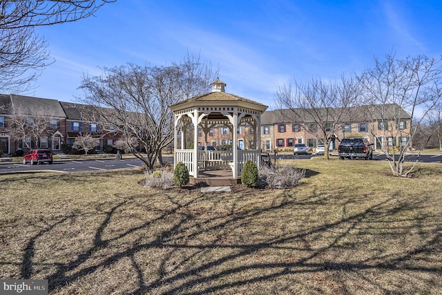 view of property's community featuring a gazebo, a yard, uncovered parking, and a residential view