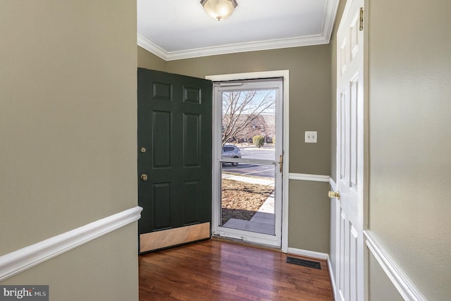 entrance foyer with dark wood-type flooring, crown molding, visible vents, and baseboards