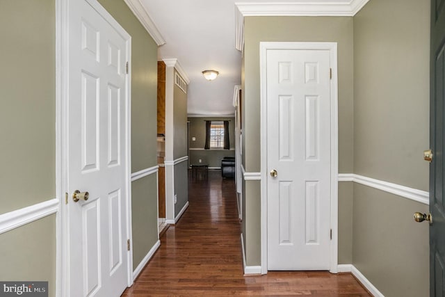 hall featuring dark wood finished floors, crown molding, baseboards, and visible vents