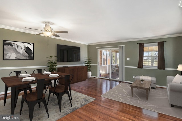 dining space featuring baseboards, wood finished floors, a ceiling fan, and ornamental molding