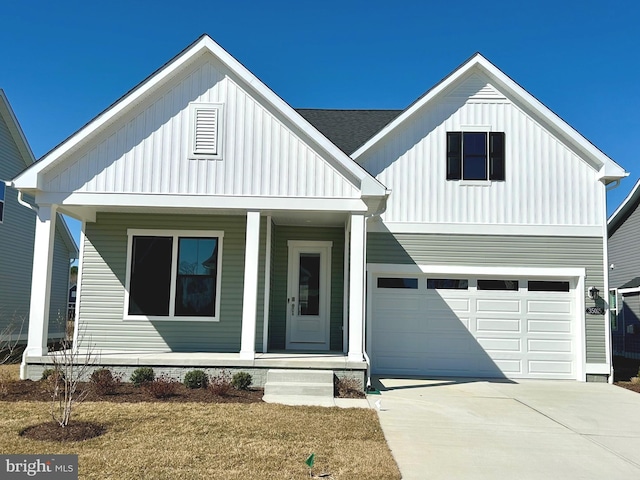 modern farmhouse with covered porch, board and batten siding, driveway, and a garage