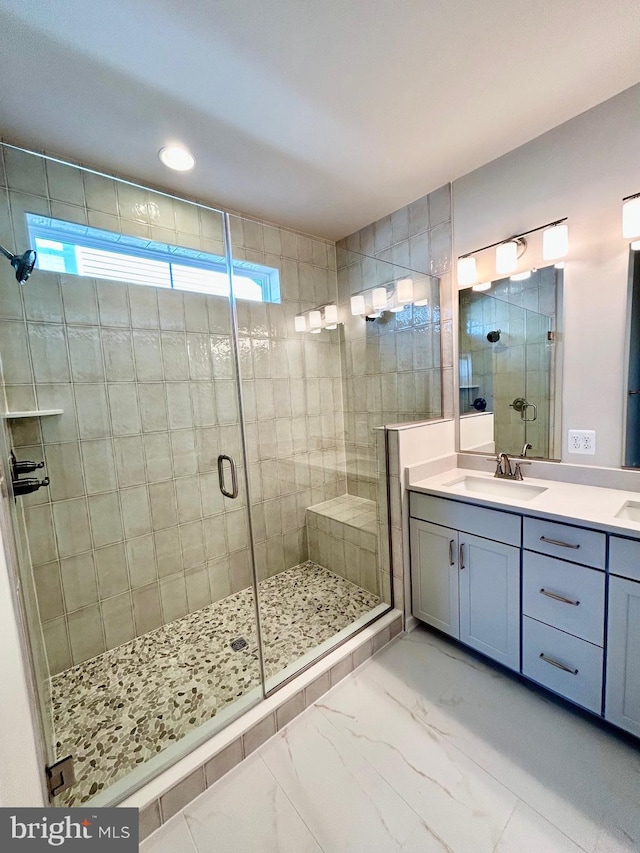 full bath with vanity, marble finish floor, and a shower stall