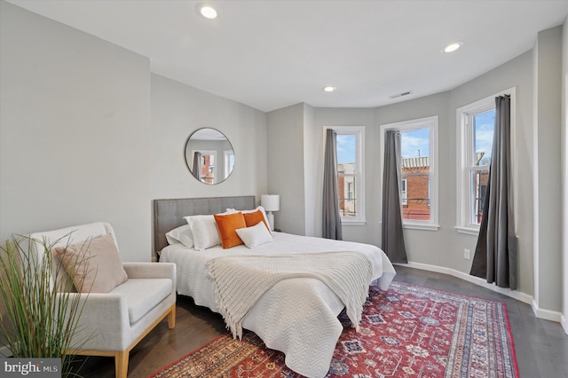 bedroom with recessed lighting, wood finished floors, visible vents, and baseboards