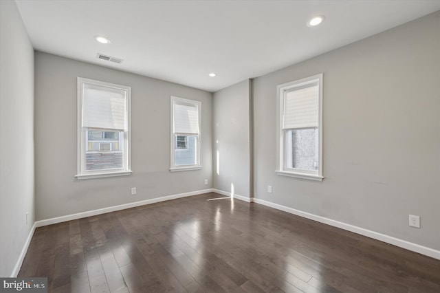 unfurnished room with recessed lighting, visible vents, and dark wood-style floors