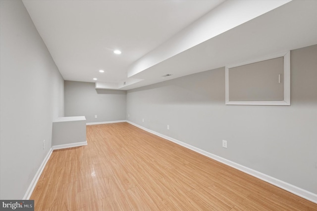 finished below grade area featuring recessed lighting, light wood-type flooring, and baseboards