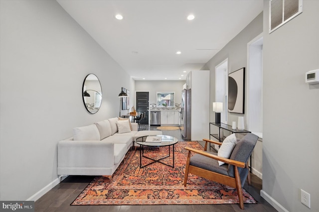 living area featuring dark wood-type flooring, recessed lighting, visible vents, and baseboards