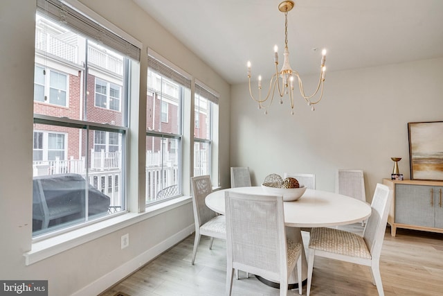 dining space featuring a notable chandelier, wood finished floors, and baseboards