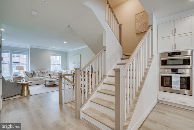 staircase with recessed lighting, wood finished floors, baseboards, and ornamental molding