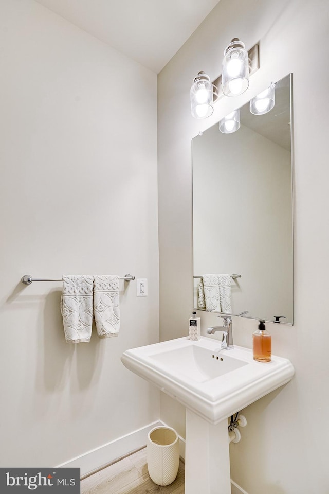 bathroom featuring a sink, baseboards, and wood finished floors