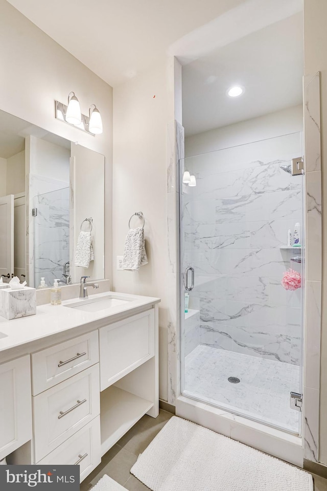 full bath featuring vanity and a marble finish shower