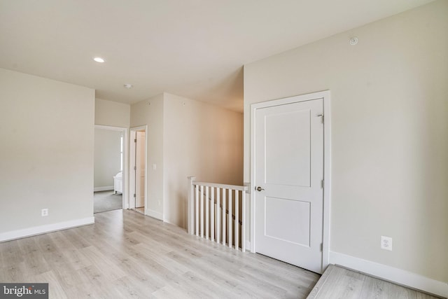 spare room with recessed lighting, baseboards, and light wood-type flooring