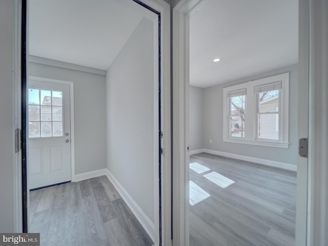 doorway with wood finished floors and baseboards