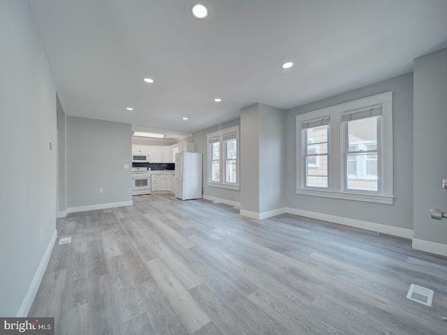 unfurnished living room featuring recessed lighting, visible vents, baseboards, and light wood-style flooring