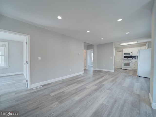 unfurnished living room with visible vents, recessed lighting, baseboards, and light wood-type flooring