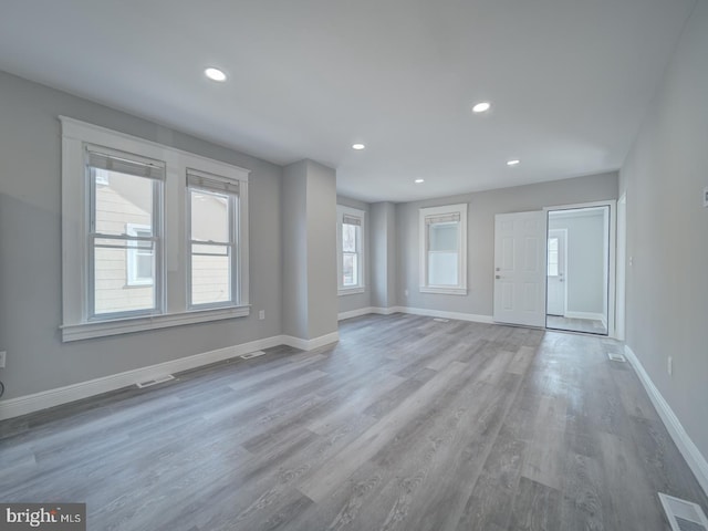 unfurnished living room featuring recessed lighting, visible vents, baseboards, and wood finished floors