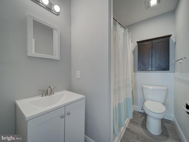 bathroom featuring visible vents, toilet, a shower with curtain, wood finished floors, and vanity