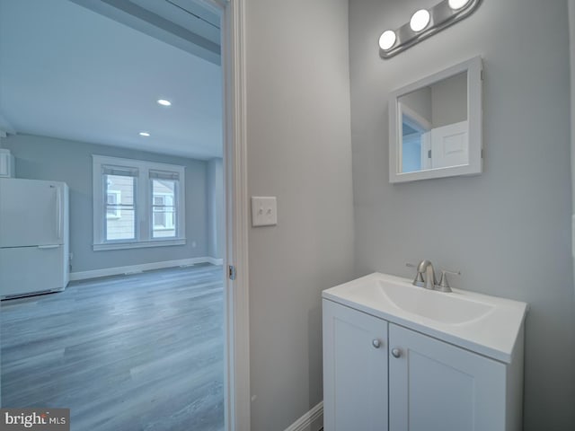 bathroom with vanity, baseboards, and wood finished floors