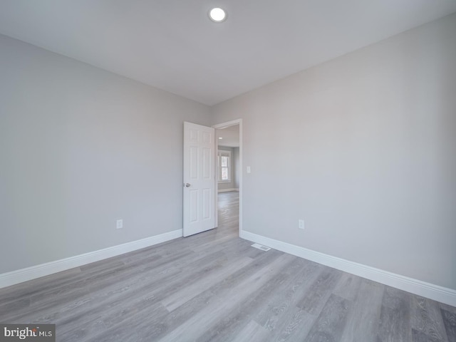 spare room featuring recessed lighting, visible vents, baseboards, and wood finished floors